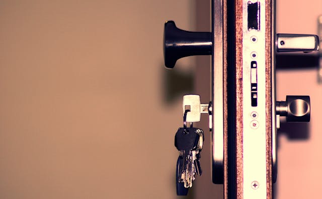 Set of keys hanging from a lock in an open door